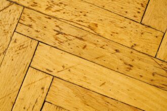 Parquet en bois ancien avec rayures et marques d'usure visibles