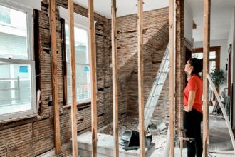 Maison en cours d'extension avec échafaudages et matériaux de construction visibles