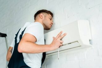 Technicien installant un système de climatisation dans une maison