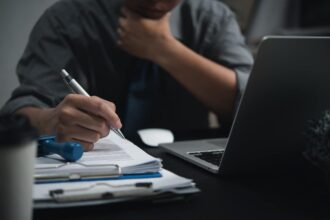 Homme réalisant des démarches administratives à son bureau le soir