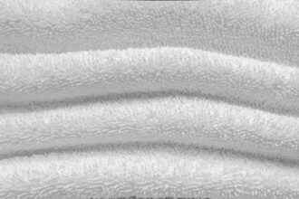 Serviette en tissu éponge de bambou pliée sur une surface claire
