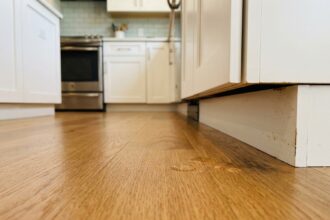 Parquet en chêne clair avec gouttelettes d'eau perlant sur le vernis protecteur dans une cuisine moderne